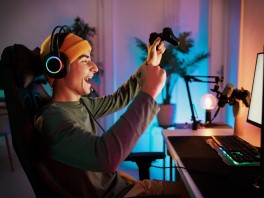 A guy gaming at a computer wearing headphones