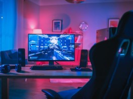 A gaming space featuring a desktop computer and pink and blue lighting