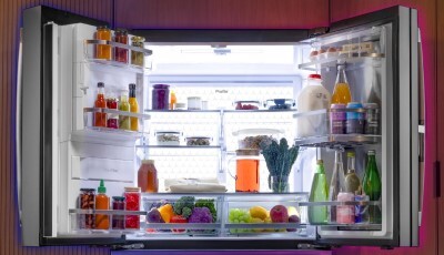An open GE Profile Kitchen Assistant Refrigerator showing the LED wall backlighting all contents