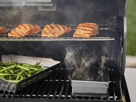 An image of a bunch of cuts of fish and vegetables on a grill.