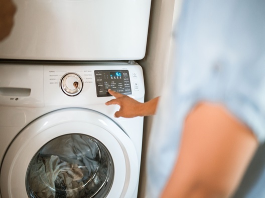 A person adjusting the settings on their washer.