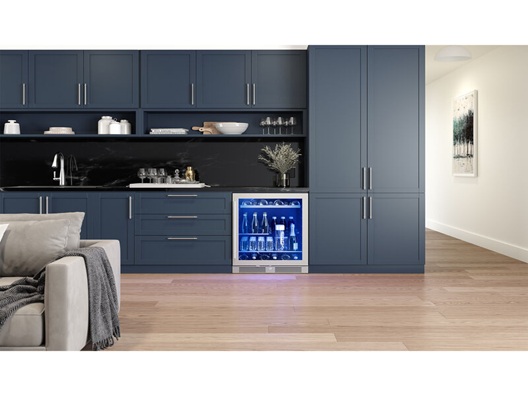 A beverage center built into some cabinets in an open room near a couch.