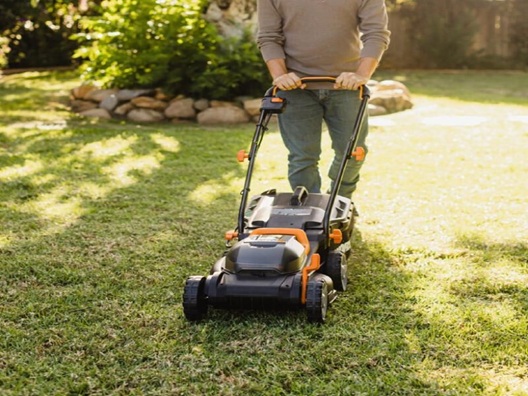 Someone mowing their yard with a lawnmower.