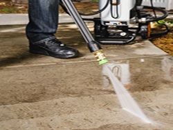 Someone pressure washing concrete.