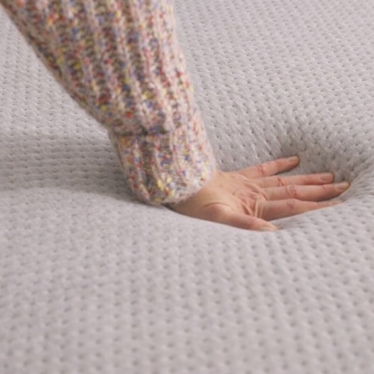 Someone pushing down on a mattress.
