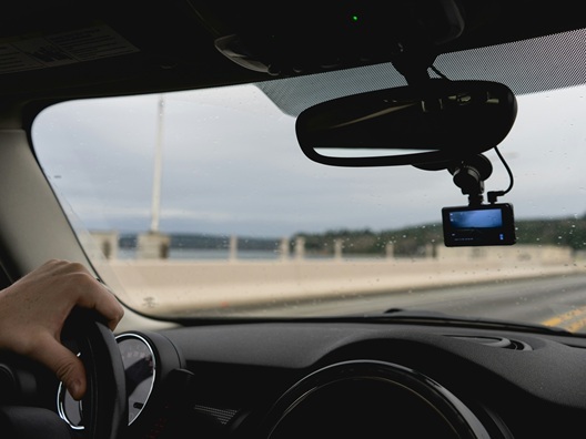 Someone driving a car with a dashcam installed in front of them.