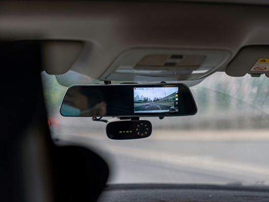 Someone driving a car with a dashcam pointing back into the car.