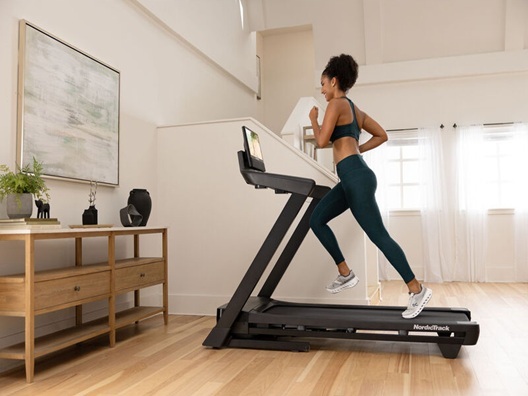 A woman running on a foldable treadmill.
