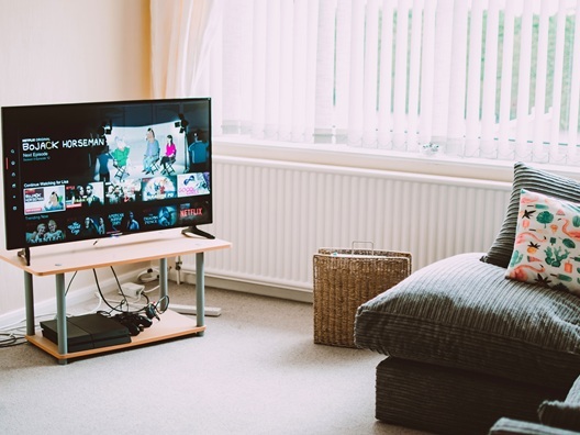 A TV on a TV stand in front of a couch.