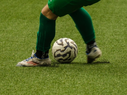A person kicking a soccer blur but their feet look blurry.