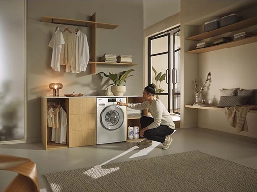 A man adjusting the settings on a washer.